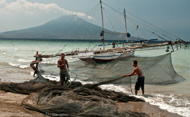 rybacy składają sieć przed wypłynięciem na połowy w tle Ile Ape