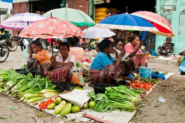 handlarki chowają się pod parasolami przed ostrym słońcem 